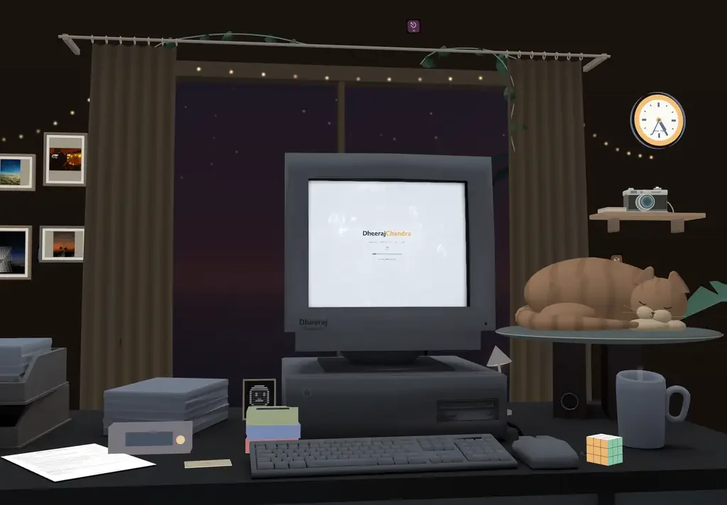 Desktop portfolio room with its computer, curtains, camera and sleeping cat
